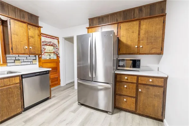 a kitchen with stainless steel appliances a refrigerator cabinets and a sink