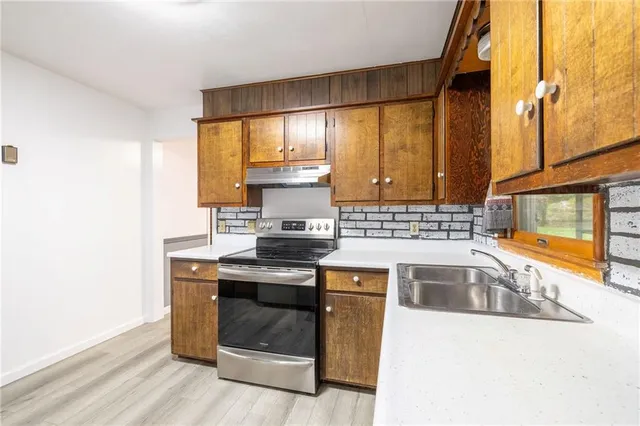 a kitchen with stainless steel appliances granite countertop a stove and a sink
