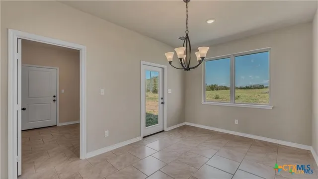 a view of a kitchen with granite countertop cabinets a stove and a chandelier