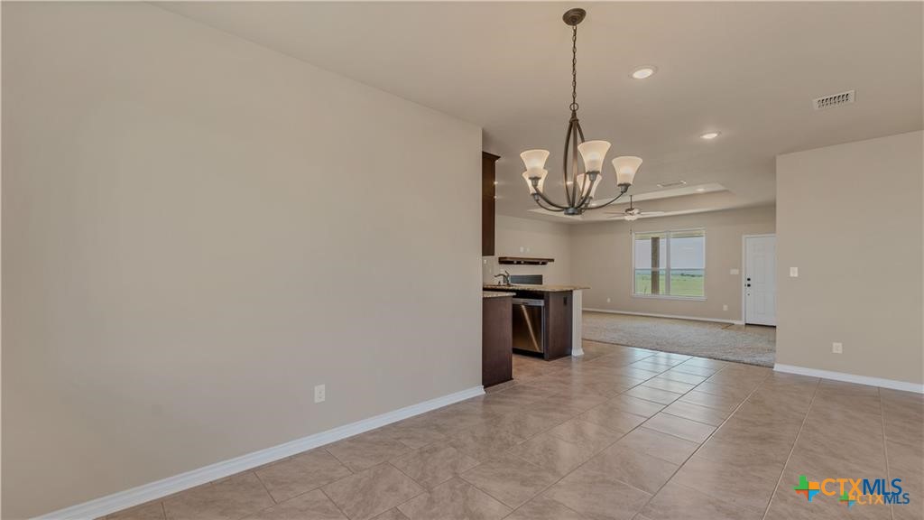 559 Bylerpool Road Kingsbury, TX 78638 - Photo 24 of 36 a view of a kitchen with granite countertop cabinets a stove and a chandelier