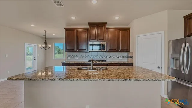 an empty room with windows and fireplace
