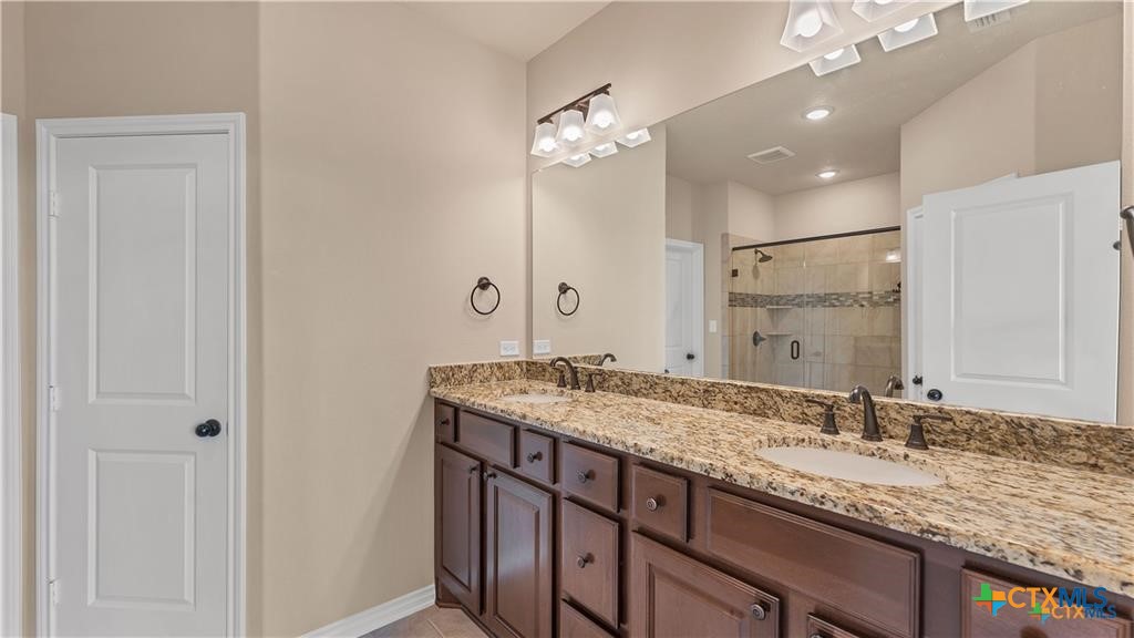 559 Bylerpool Road Kingsbury, TX 78638 - Photo 30 of 36 a bathroom with a granite countertop sink and a mirror