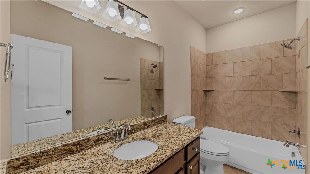 559 Bylerpool Road Kingsbury, TX 78638 - Photo 33 of 36 a bathroom with a granite countertop sink a mirror and a bathtub