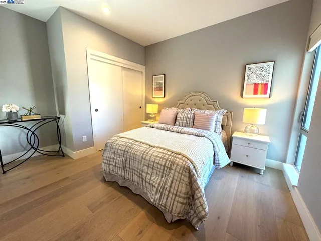 a bedroom with a bed and wooden floor