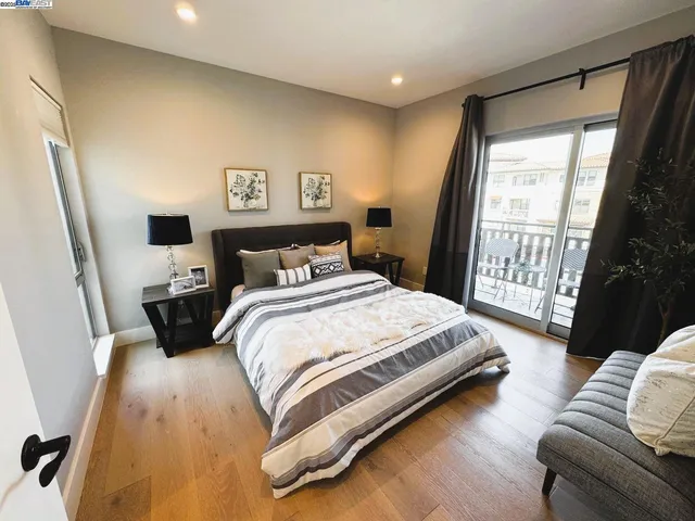 a bedroom with a bed a couch and a large window