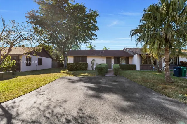 a front view of a house with a yard and trees