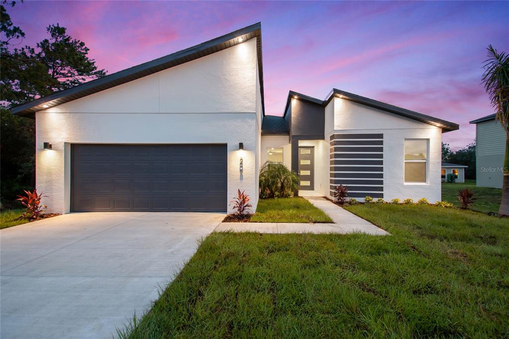 2177 Rio Grande Canyon Loop Poinciana, FL 34759 - Photo 1 of 1 a front view of a house with a yard and garage