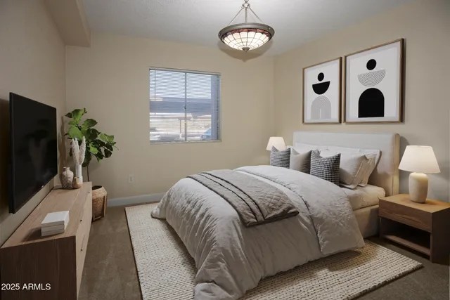 a bedroom with bed and a flat tv screen on dresser