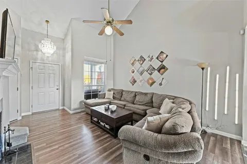 a living room with furniture ceiling fan and a wooden floor