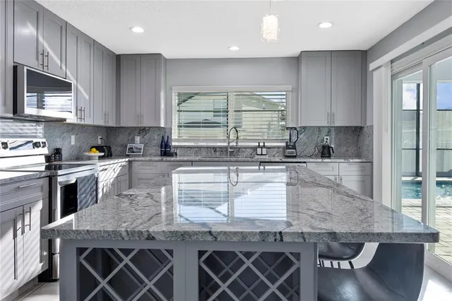 a kitchen with granite countertop wooden cabinets a stove a sink and a window