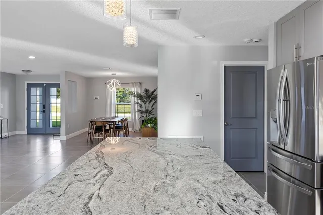 a view of a kitchen with refrigerator and dining table