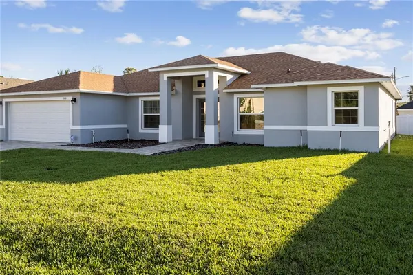 a front view of a house with a yard and garage