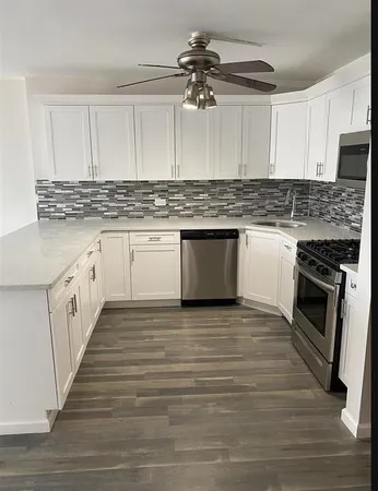 a kitchen with kitchen island granite countertop a sink cabinets and stainless steel appliances