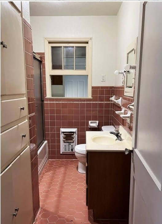 809 North 8th Street Temple, TX 76501 - Photo 14 of 20 Tiled flooring and walls create a cohesive look in this well-appointed bath, featuring a vanity and window.