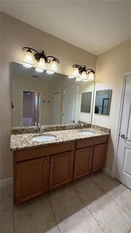 a bathroom with a granite countertop sink and mirror