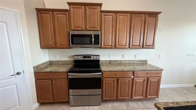 a kitchen with kitchen island granite countertop a sink stove and refrigerator