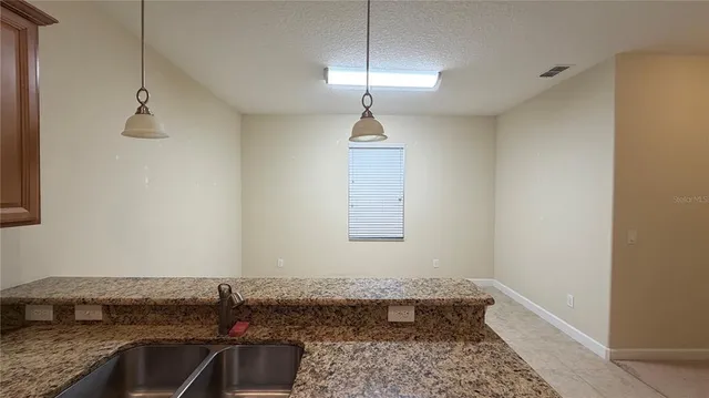 a view of a kitchen with kitchen island a sink and a refrigerator