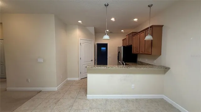 a kitchen with stainless steel appliances granite countertop a refrigerator and a stove