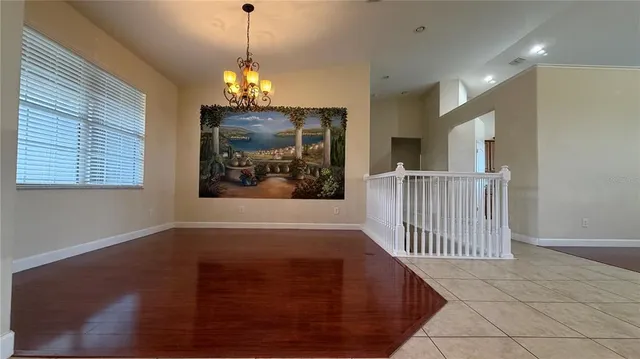 a view of a room with wooden floor windows and a chandelier