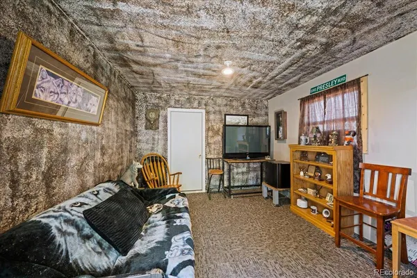 a living room with furniture a flat screen tv and a window