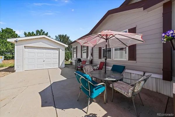 a view of a patio with a table and chairs under an umbrella
