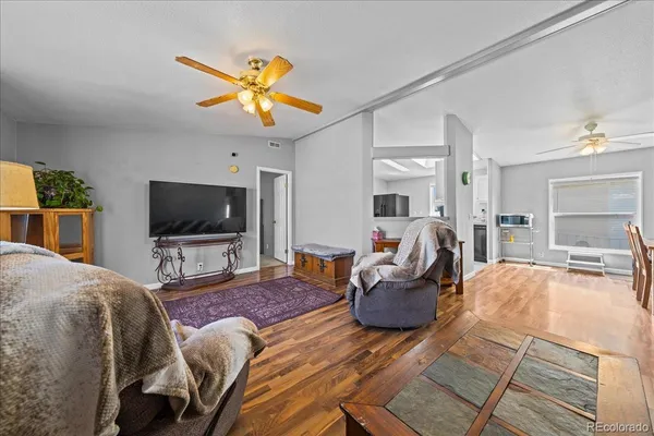 a living room with furniture a flat screen tv and a chandelier