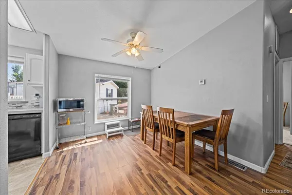 a view of a dining room with furniture a chandelier and wooden floor