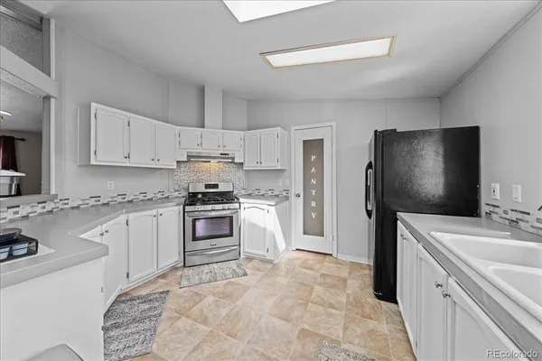 a kitchen with white cabinets and appliances