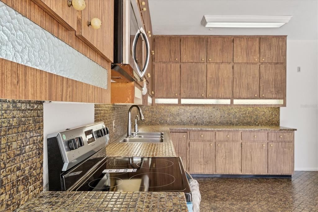 2605 Desoto Road Sarasota, FL 34234 - Photo 25 of 57 a kitchen with a sink a stove and a microwave oven