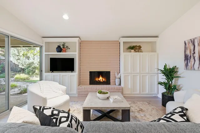 a living room with furniture a flat screen tv and a large window