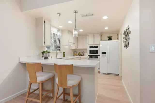 a kitchen with kitchen island a sink stove and refrigerator