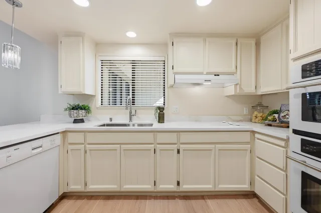 a kitchen with white cabinets and white appliances
