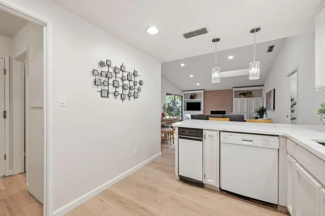 a kitchen with white cabinets and sink