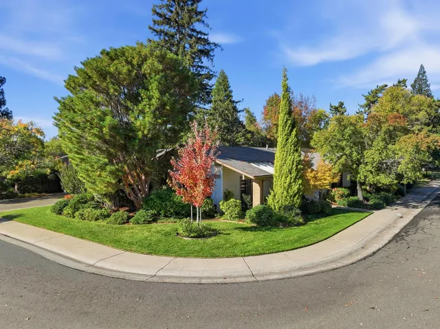 a view of a house with a garden and trees