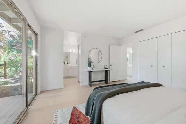 a bedroom with a bed mirror and a large window