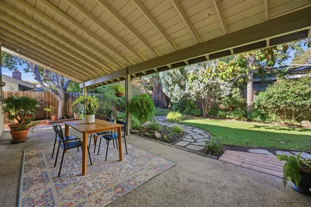 a view of a patio with table and chairs potted plants with wooden floor