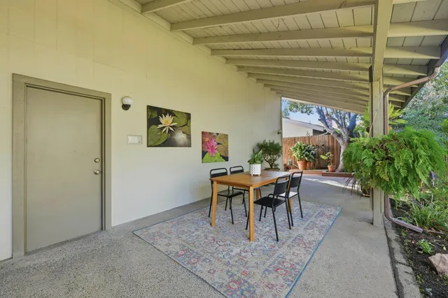 a dining room with furniture and a potted plant