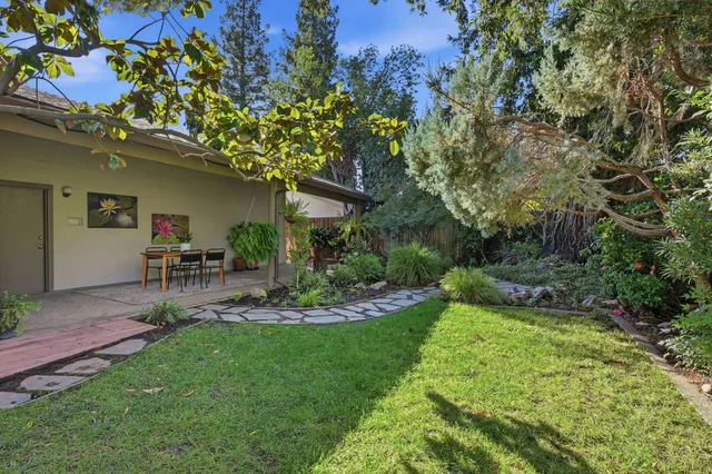 a view of a chair and table in backyard of the house