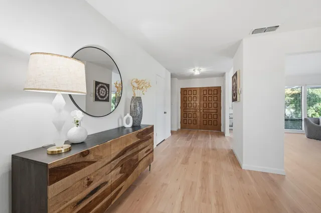 a view of a hallway with entryway wooden floor and front door
