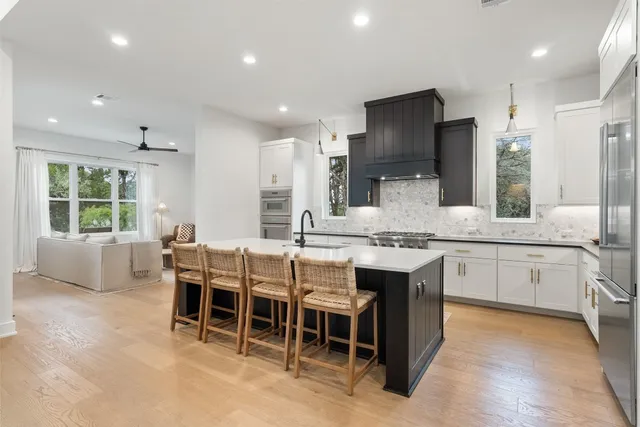 a large kitchen with cabinets table and chairs