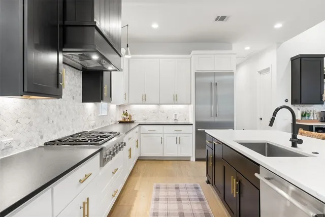 a kitchen with granite countertop a sink stainless steel appliances and cabinets