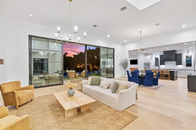 a living room with furniture kitchen view and large windows