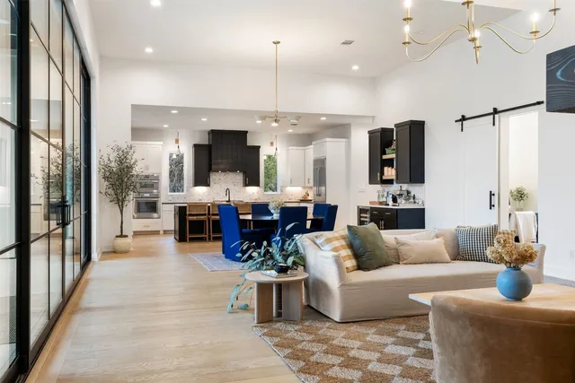 a living room with furniture kitchen view and a large window