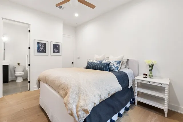 a spacious bedroom with a bed and a chandelier