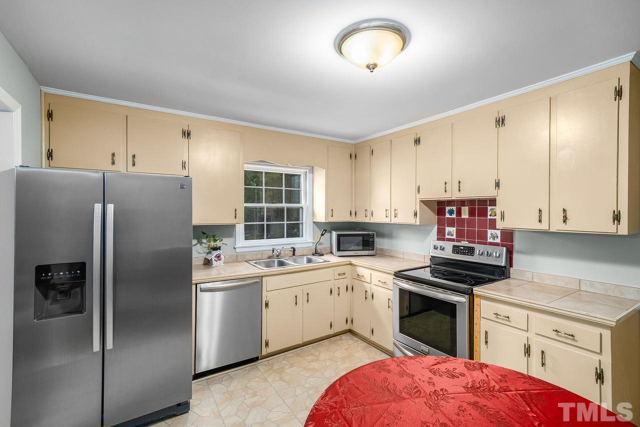 709 Merwin Road Raleigh, NC 27606 - Photo 7 of 30 a kitchen with a sink stainless steel appliances and cabinets