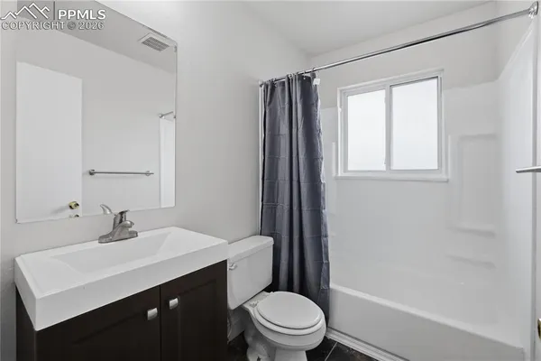 a bathroom with a sink a toilet a mirror and shower