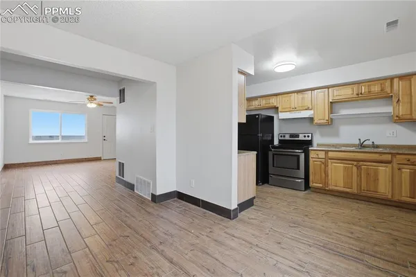 a kitchen with stainless steel appliances kitchen island wooden floors and granite counter tops
