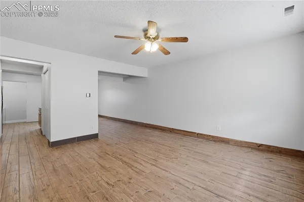 a view of empty room with wooden floor