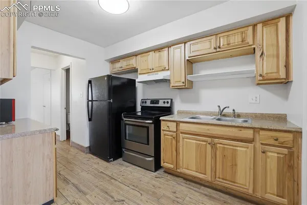 a kitchen with stainless steel appliances granite countertop a refrigerator and a stove top oven