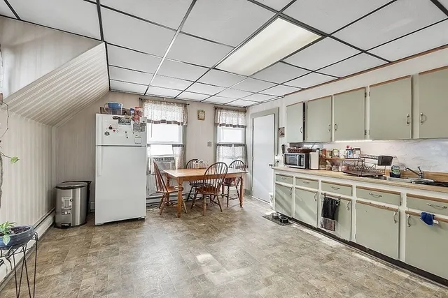 a kitchen with refrigerator and table